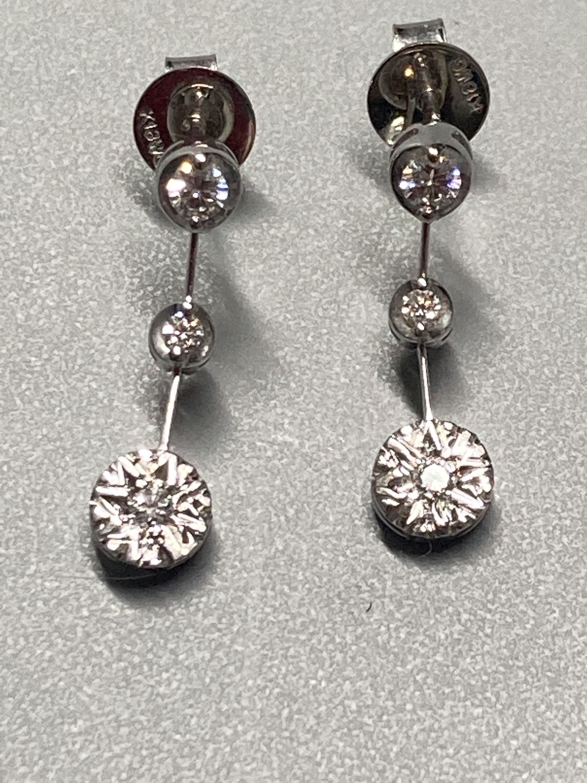 A modern pair of 18ct white gold and illusion set three stone diamond drop earrings, 19mm, gross 2.3 grams.